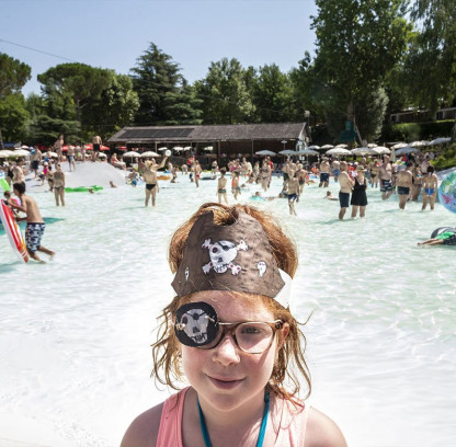Bambina gioca in piscina nel villaggio per famiglie